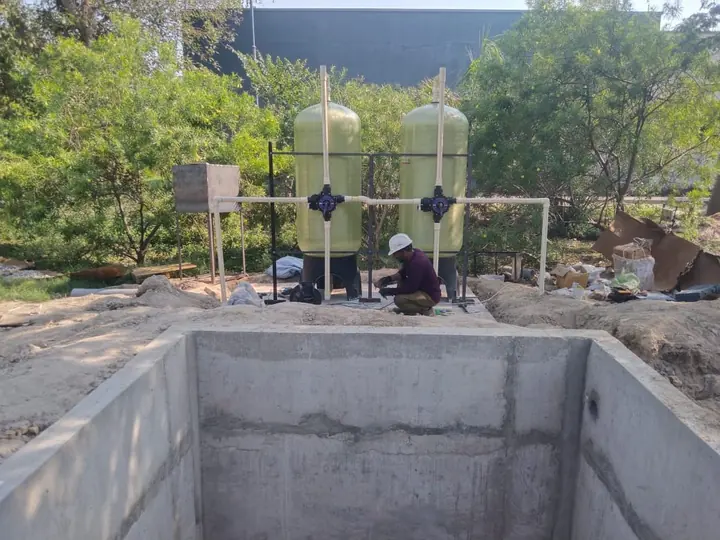 Water filtration vessels installed beside a storage structure